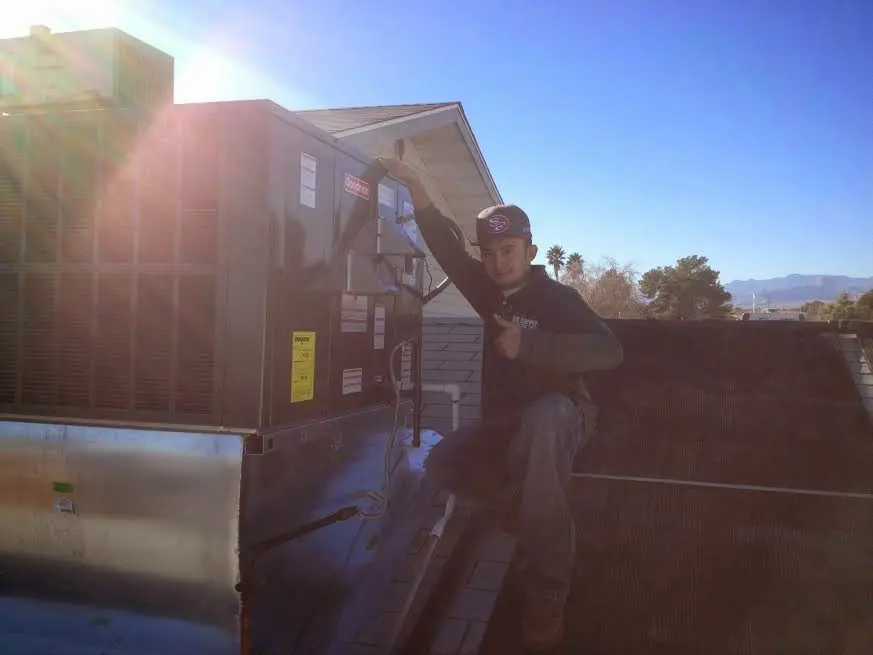 HVAC technician performing Heat Pump Repair on a rooftop unit in Sturgis